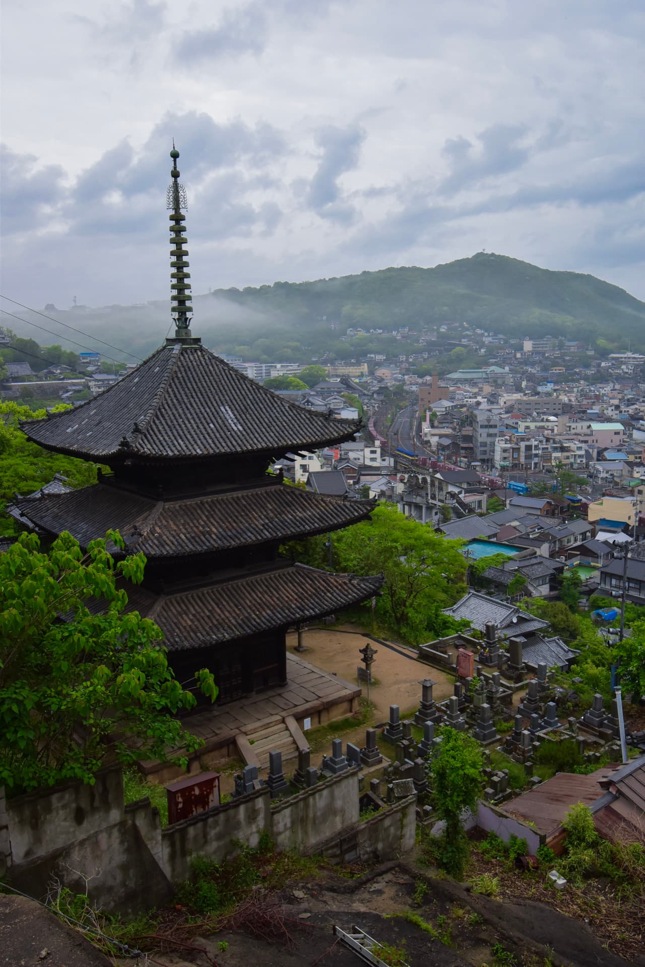 A misty pagoda above a hillside town
