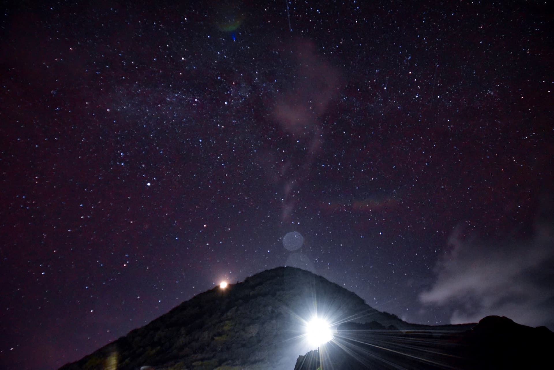 A sky full of stars over a mountain silhouette